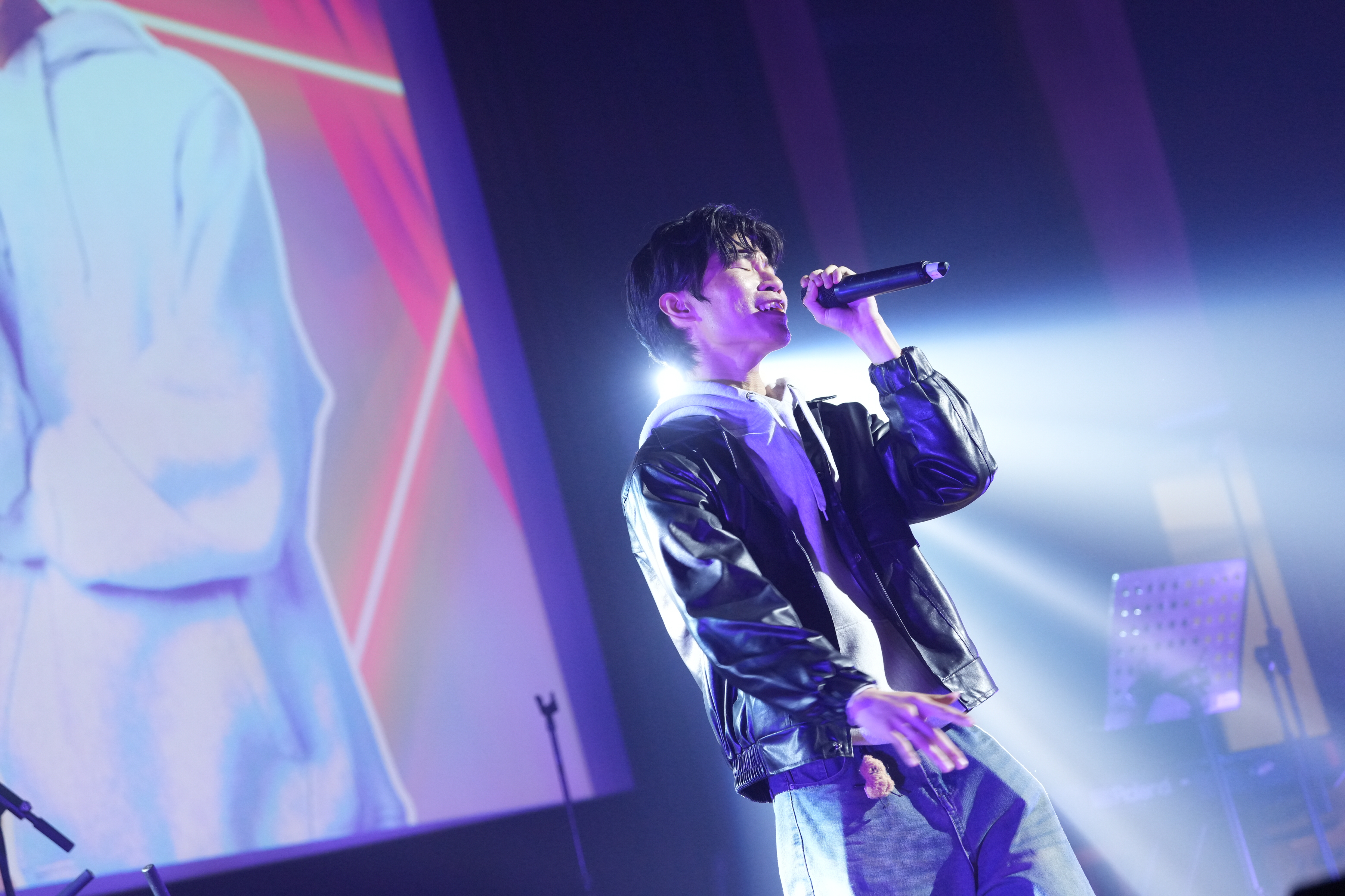 Junoz singing with eyes closed on stage